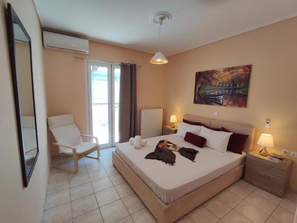1 dormitorio con 1 cama blanca grande y 1 silla en John's Apartment 2 in Argostoli, en Argostoli