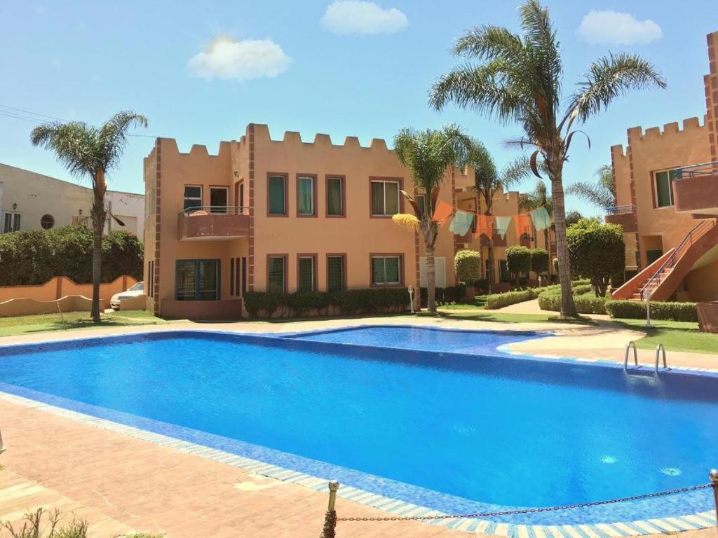 傑迪代的住宿－Duplex Riad Sidi Bouzid，棕榈树屋前的游泳池