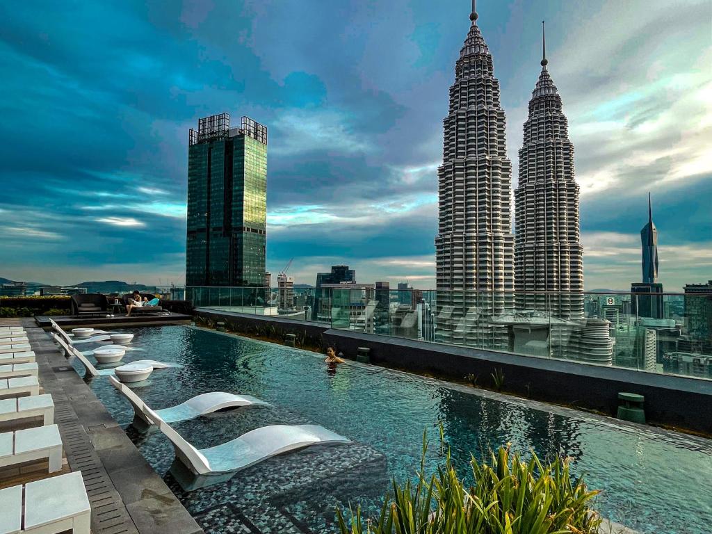 a pool on the roof of a building with tall buildings at AXQUISITE SUITES at KLCC in Kuala Lumpur