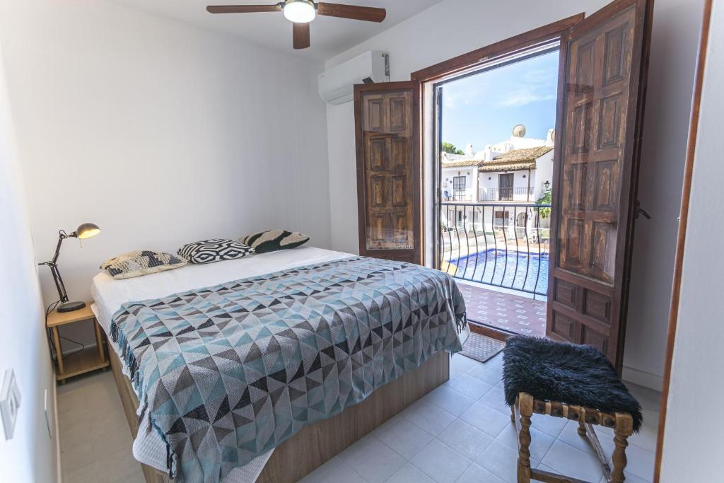 sypialnia z łóżkiem i dużym oknem w obiekcie Canovas Nerja - Nueva Nerja - Pueblo Andaluz 94 w mieście Nerja