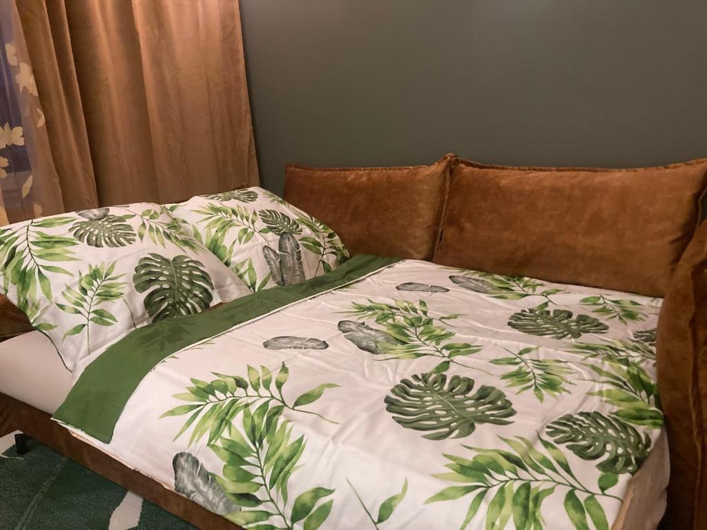 een bed met een dekbed met planten erop bij Apartament Drochaczyński in Ostrów Wielkopolski