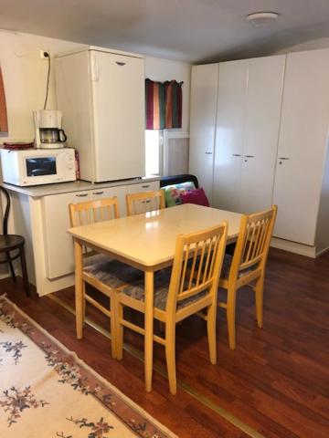 a kitchen with a wooden table and chairs and a kitchen with white cabinets at Hostel Ukonlinna in Imatra