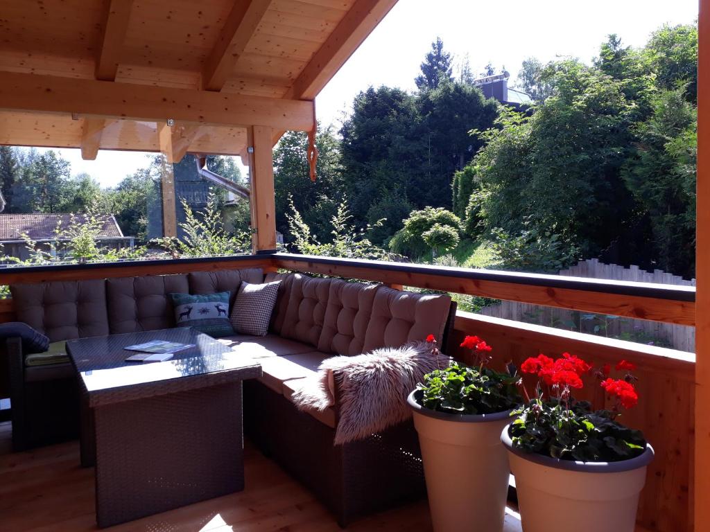 a patio with a couch and two potted plants at Chalet Sisi in Saalfelden am Steinernen Meer