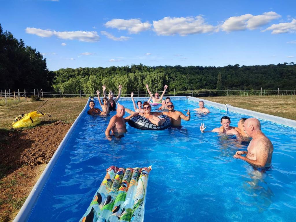 a group of people are in a swimming pool at Gîte équestre Domaine des Crins - Biron in Capdrot