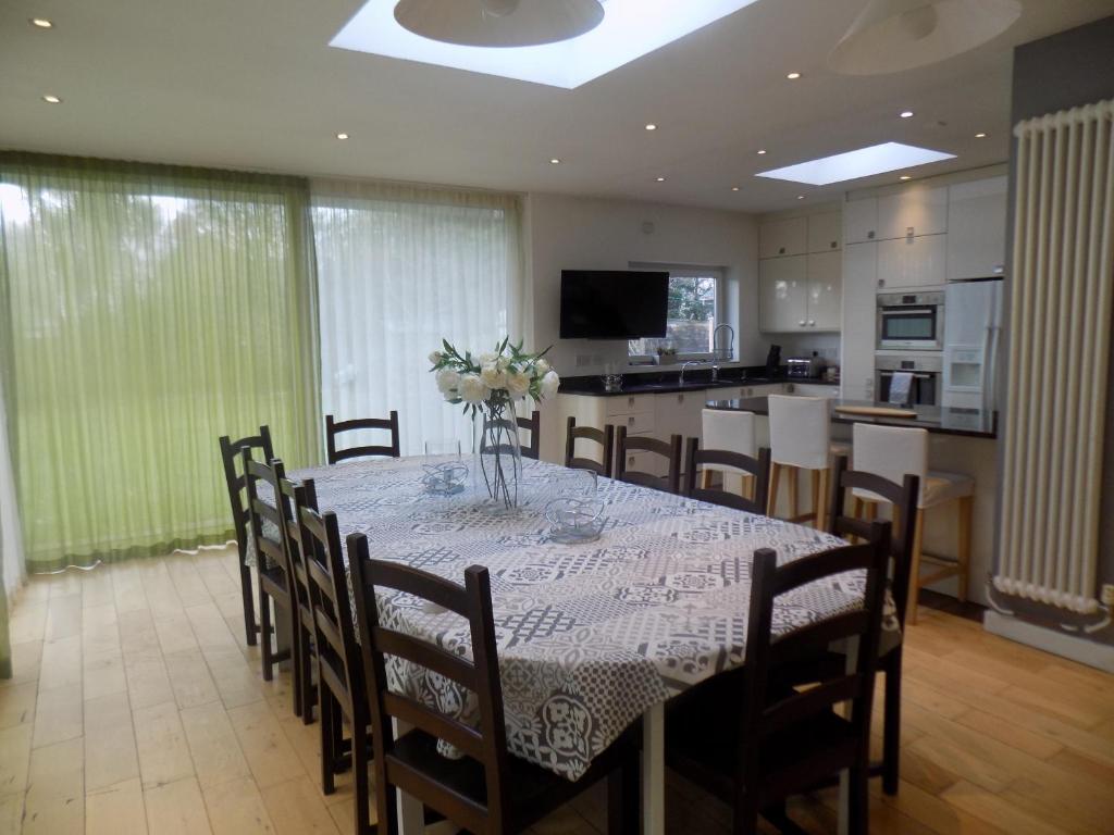 une salle à manger avec une table et des chaises ainsi qu'une cuisine dans l'établissement Rhiwbina House, à Cardiff