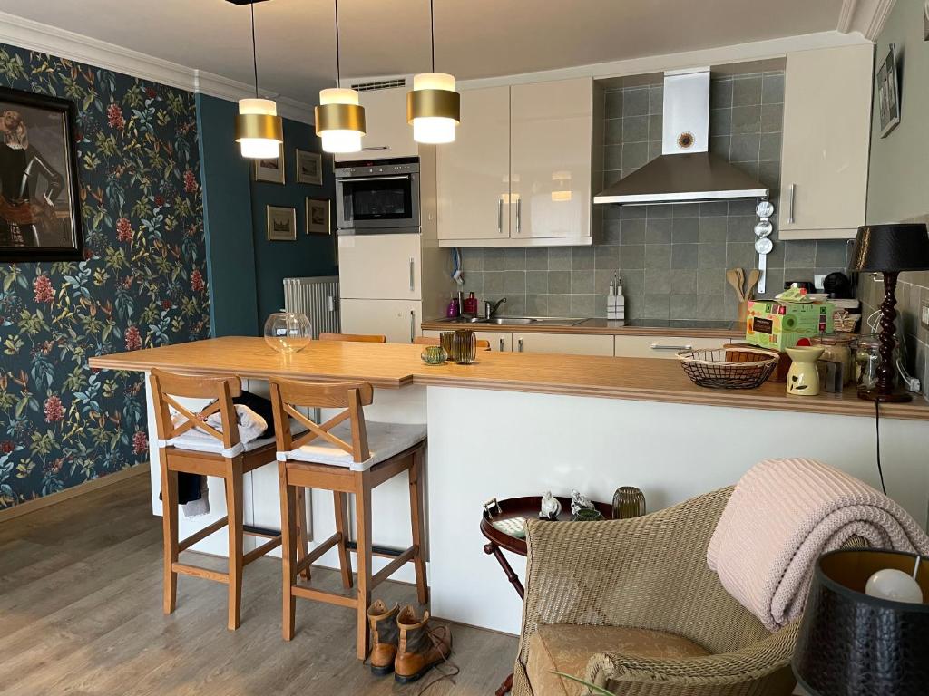 a kitchen with a wooden table in a room at La Corneille en Mer in Ostend