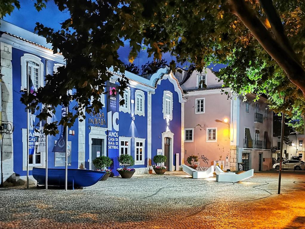 a blue and white building on a street at night at A Casa do Chapéu de Palha in Setúbal