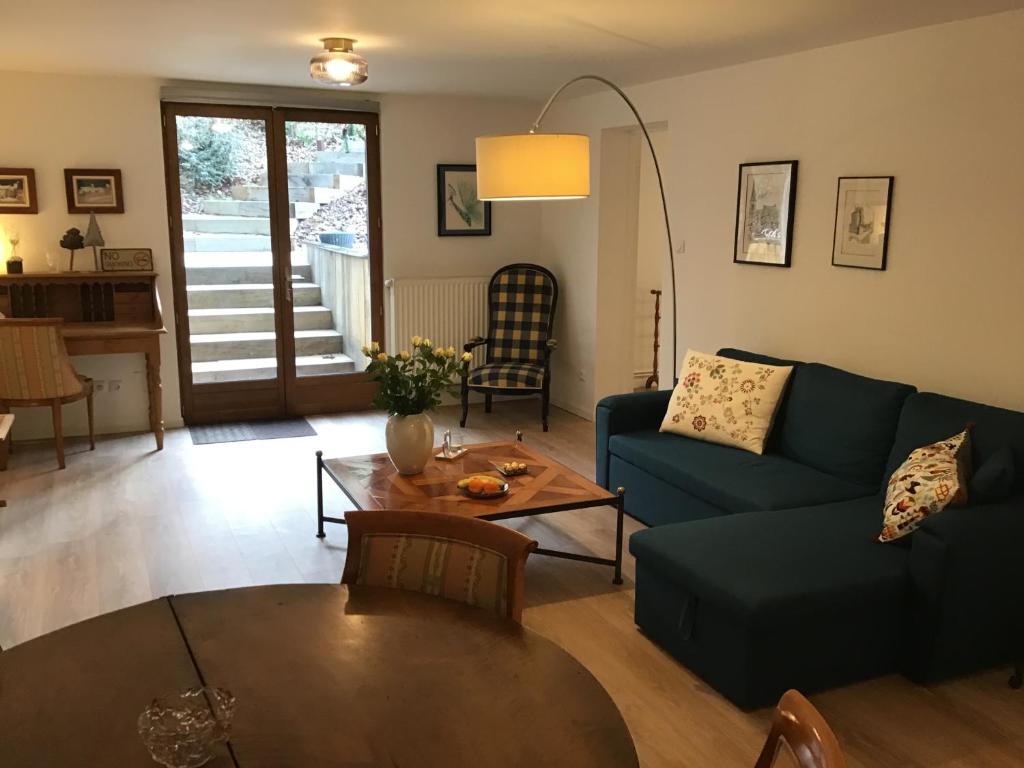 ein Wohnzimmer mit einem blauen Sofa und einem Tisch in der Unterkunft L'atelier du gîte bleu in Willgottheim