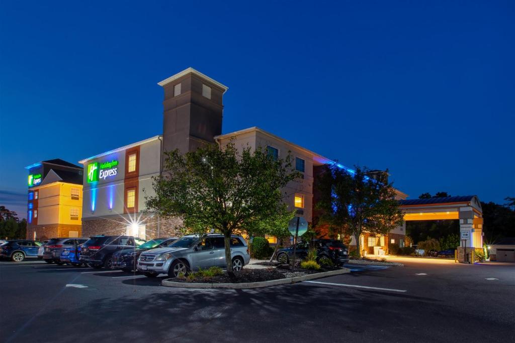 un estacionamiento con autos estacionados frente a un edificio en Holiday Inn Express Absecon-Atlantic City Area, an IHG Hotel en Absecon
