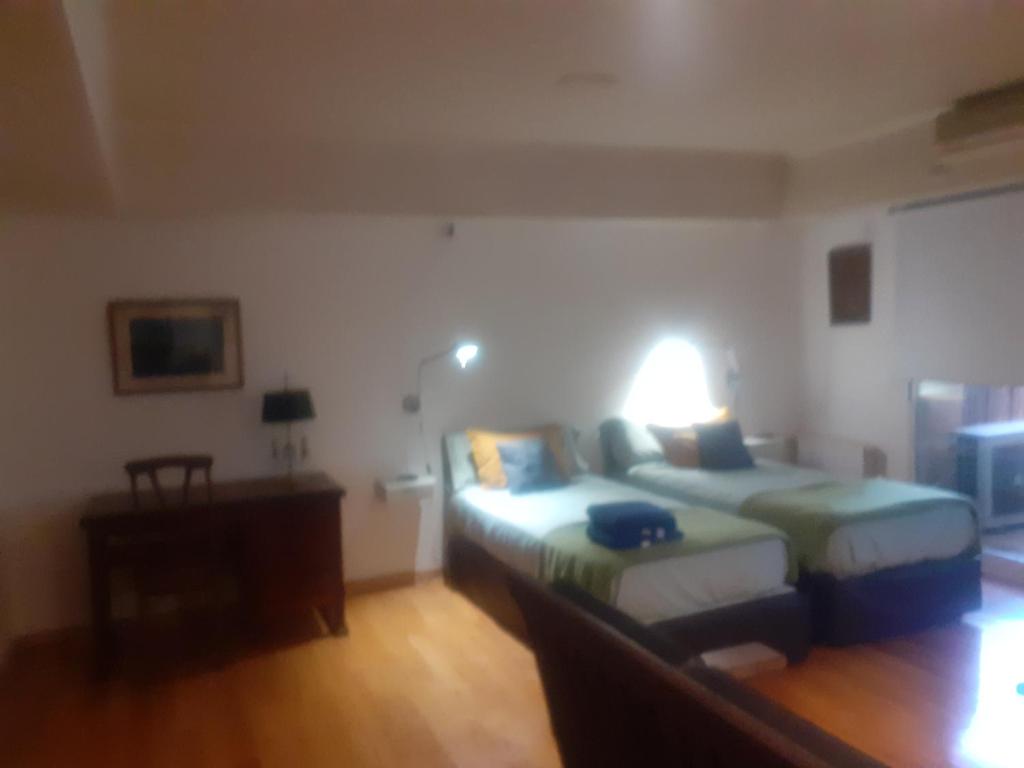 1 dormitorio con 2 camas y escritorio con lámpara en Bambú Soho en Buenos Aires