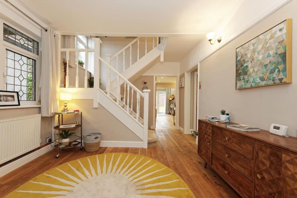 un grand salon avec un escalier et un tapis dans l'établissement Beautiful Beach Side 4 Bed House, à Kent