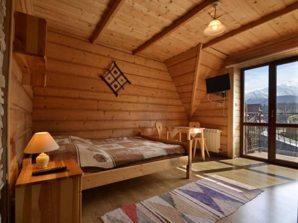 1 dormitorio con 1 cama y 1 mesa en una habitación en Willa U Góralki, en Murzasichle