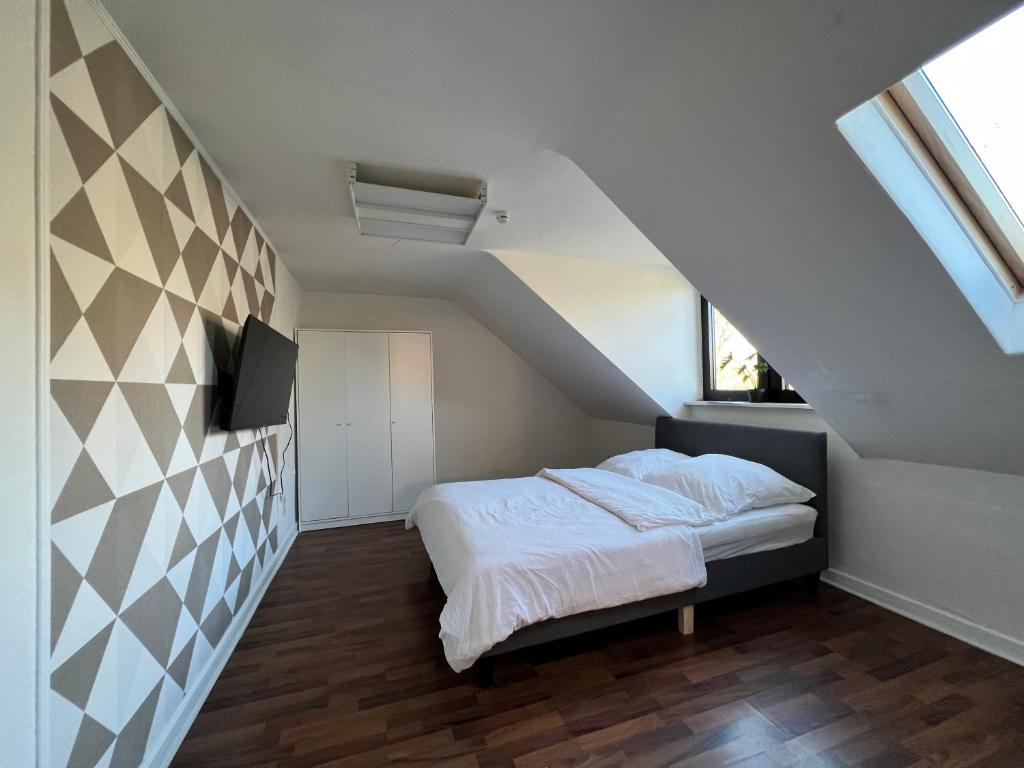 ein Schlafzimmer mit einem Bett im Dachgeschoss in der Unterkunft Monteurwohnung Mönchengladbach Geroweiher in Mönchengladbach