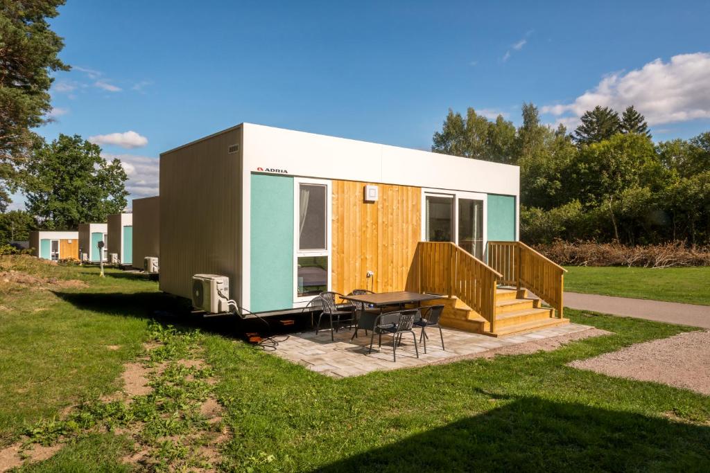 une petite maison avec une table et une terrasse dans l'établissement First Camp Glyttinge-Linköping, à Linköping