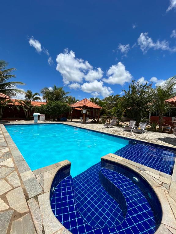 uma piscina com água azul num resort em Pousada Encanto dos Anjos em Pirenópolis