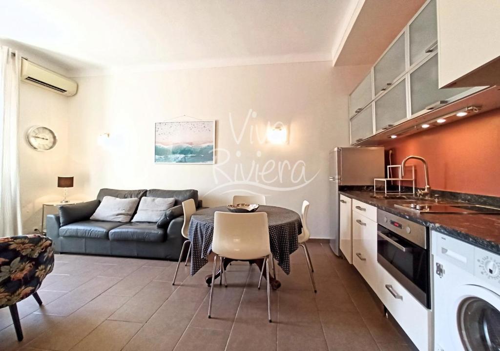 Una cocina y una sala de estar con una mesa y un sofá. en Viva Riviera - 10 Rue Florian, en Cannes