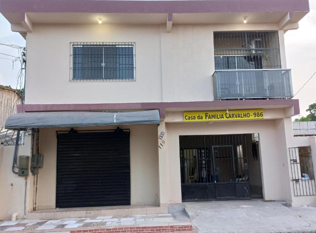 a white building with a garage and a balcony at Casa da Família Carvalho - 986 in Belém