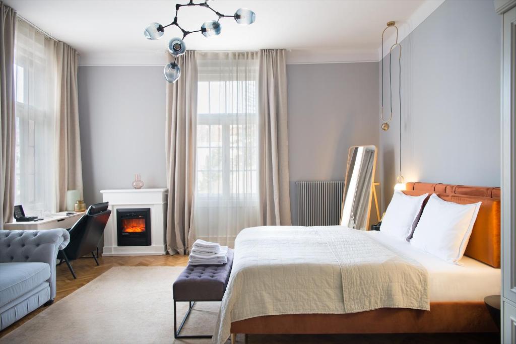 a bedroom with a bed and a chair and a fireplace at Nest in Győr