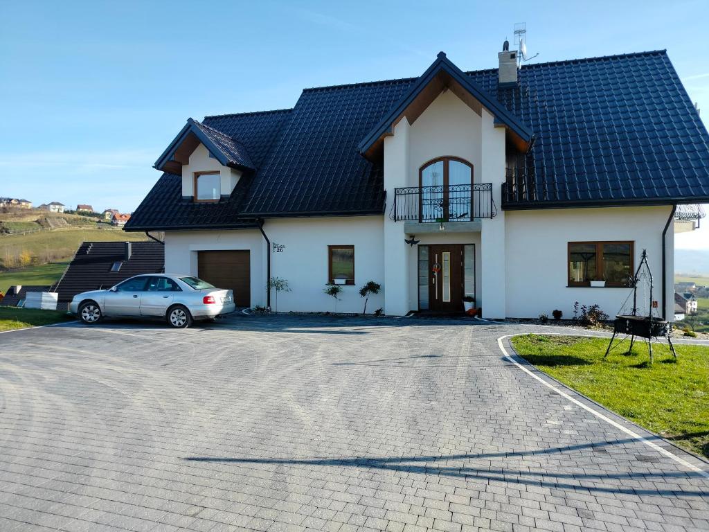 une maison avec une voiture garée dans l'allée dans l'établissement Apartament Oliwia, à Grywałd