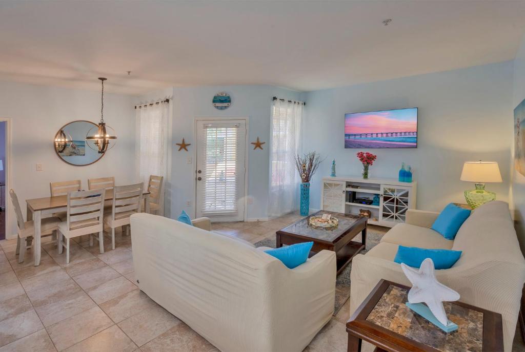 uma sala de estar com mobiliário branco e uma sala de jantar em NEW 2bed2bath condo - CLEARWATER BEACH - FREE Wi-Fi and Parking em Clearwater