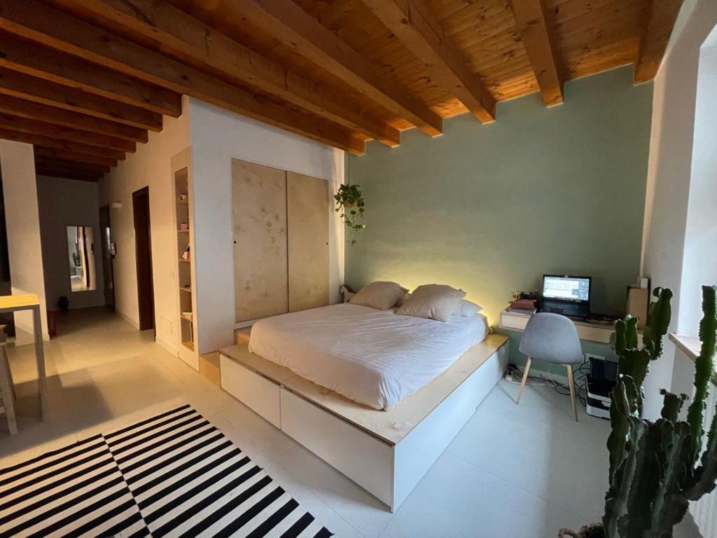 una camera da letto con un letto e una scrivania con un computer di San Nazaro 47 a Verona