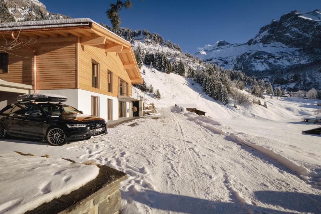 a car parked next to a house in the snow at Châlet Bärgfride in Kandersteg