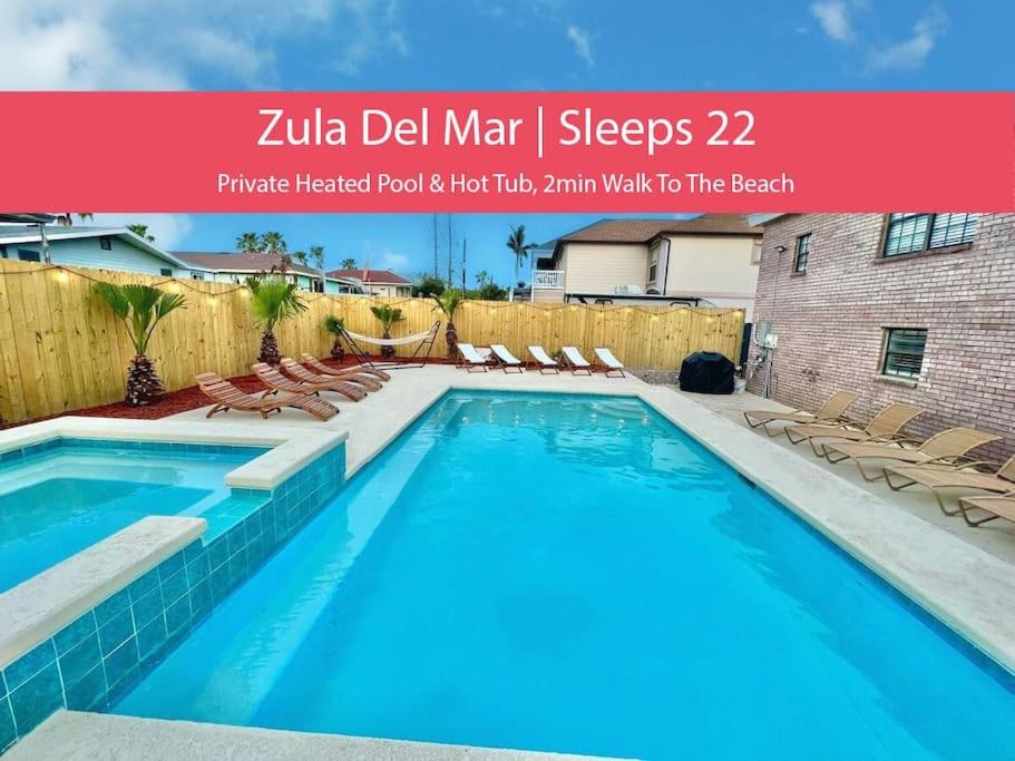 a large swimming pool with chairs next to a building at Sleeps 22, 7 bedrooms, 2min walk To The Beach, Private Heated Pool and Hot Tub, Zula Del Mar South Padre Island Texas in South Padre Island