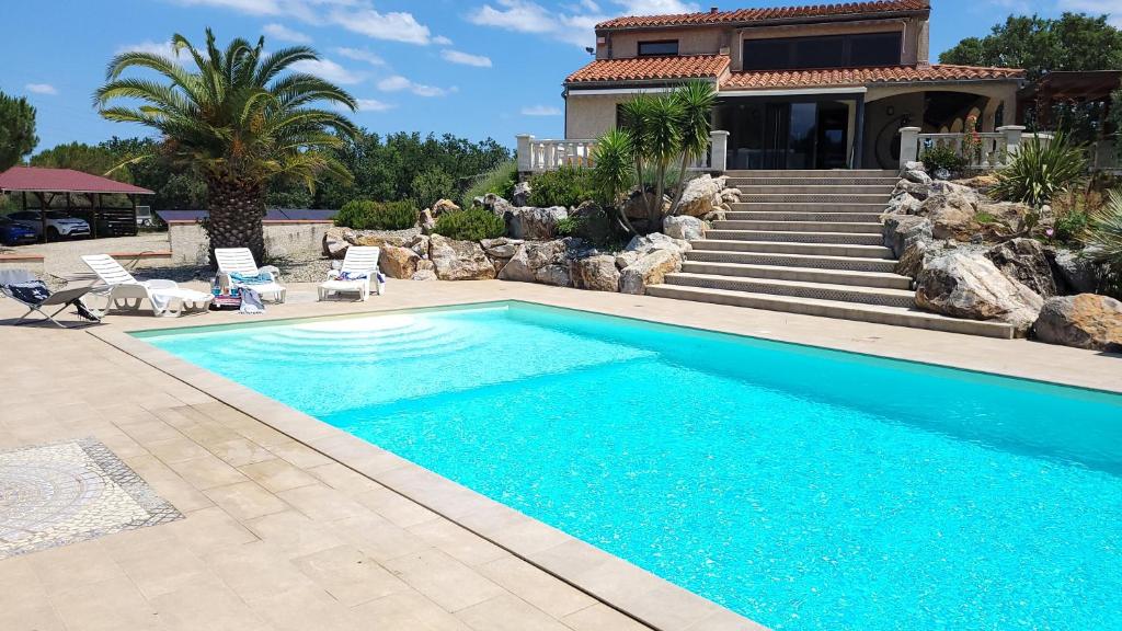 una piscina di fronte a una casa di Chambre d'hôte à la villa René a Saint-Génis