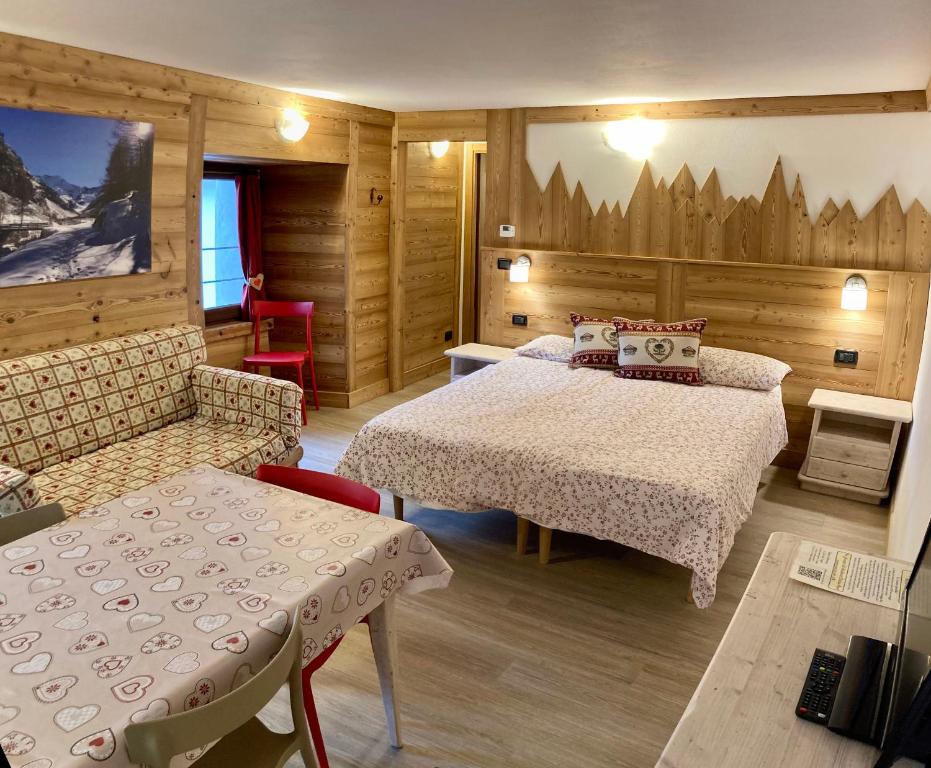 pokój hotelowy z 2 łóżkami, stołem i krzesłami w obiekcie Résidence Château Royal w mieście Cogne