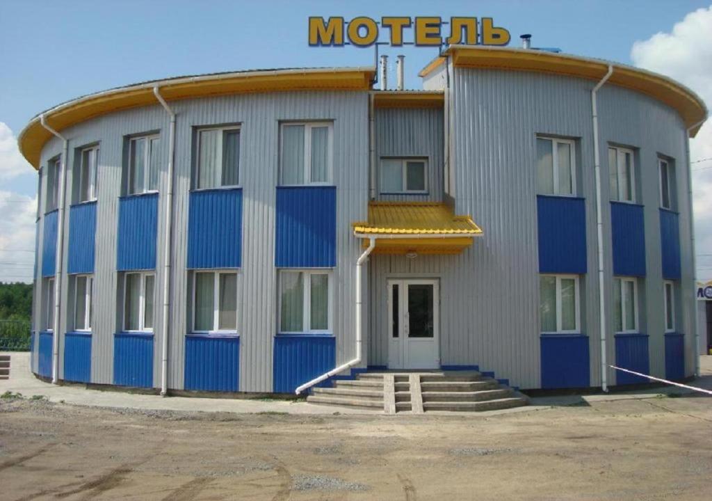 un edificio blu e bianco con un cartello sopra di Мотель ОК a Shepetovka