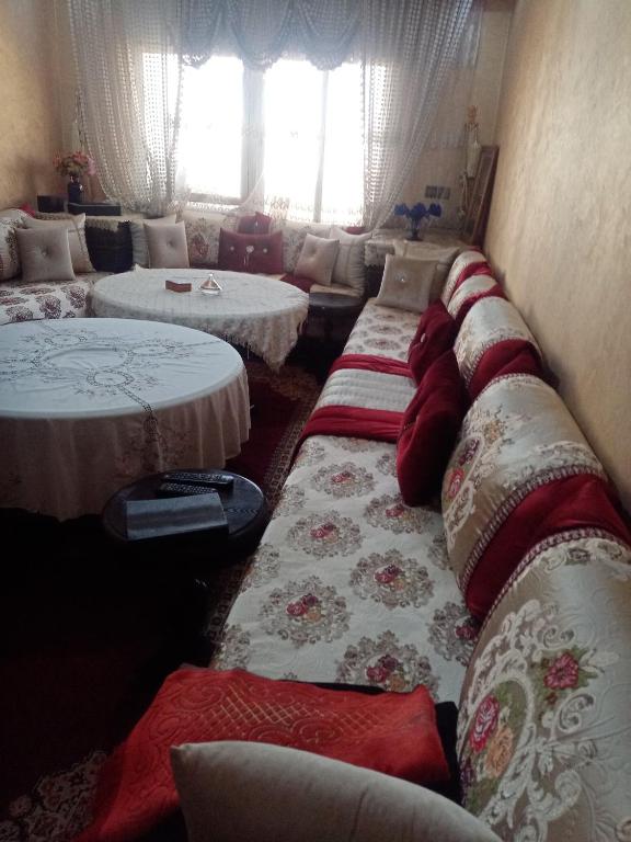 a row of beds in a room with windows at Alomran in Oulad Yakoub