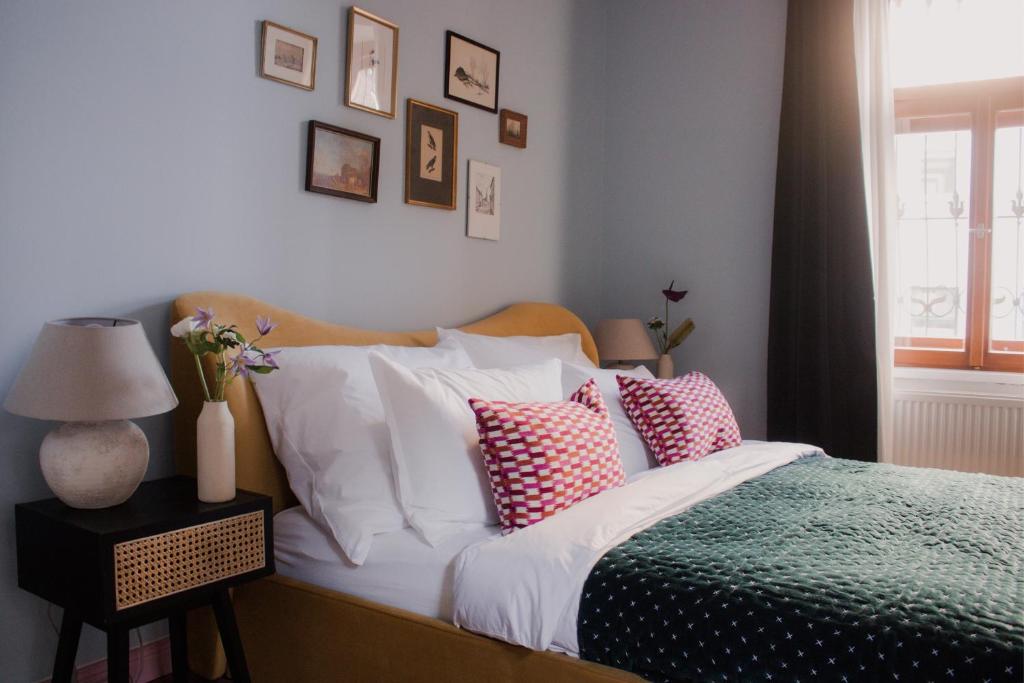 una camera da letto con un letto con cuscini bianchi e rosa di Oak House Vienna a Vienna