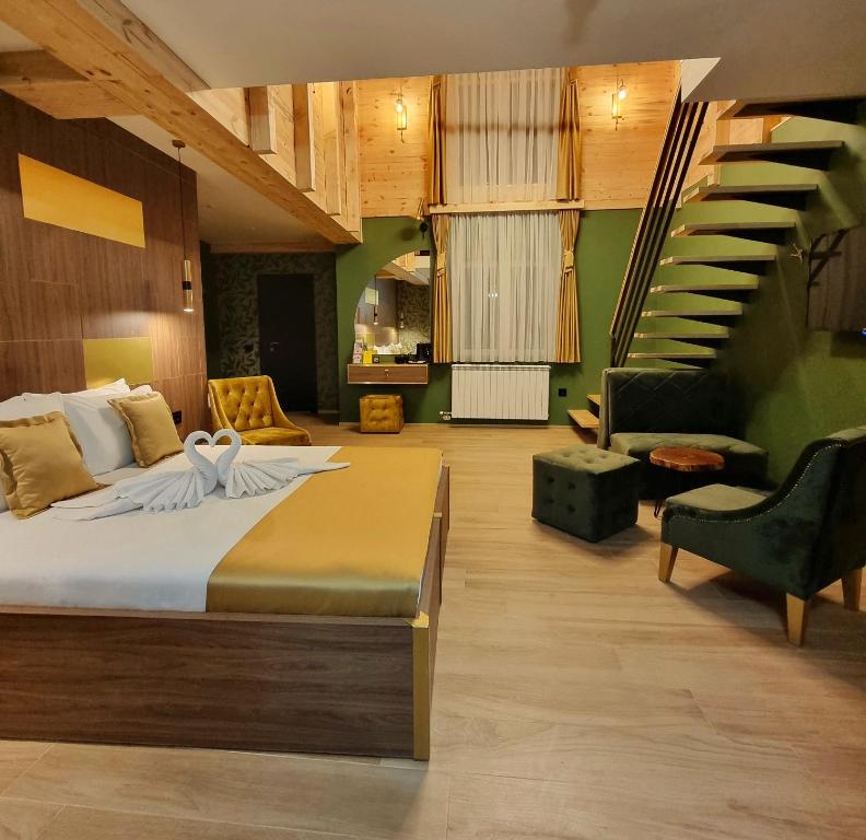 a bedroom with a large bed and a staircase at Dream House Hotel & Spa in Kolašin