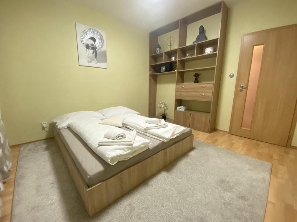 a bedroom with a bed and a book shelf at ARD City Apartment in Levice