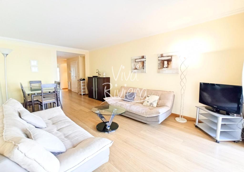 - un salon avec deux canapés blancs et une télévision dans l'établissement Viva Riviera Rue Victor Cousin, à Cannes