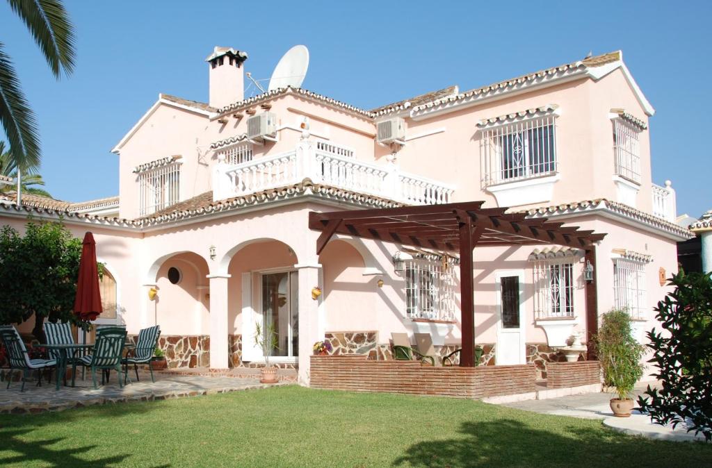 a large white house with a patio and lawn at Bonito-Sol in Sitio de Calahonda