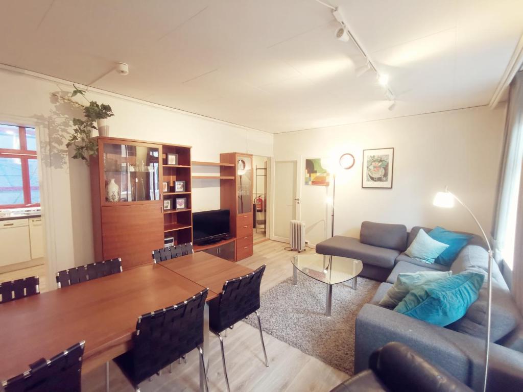 a living room with a couch and a dining room table at Inner City Center in Bergen
