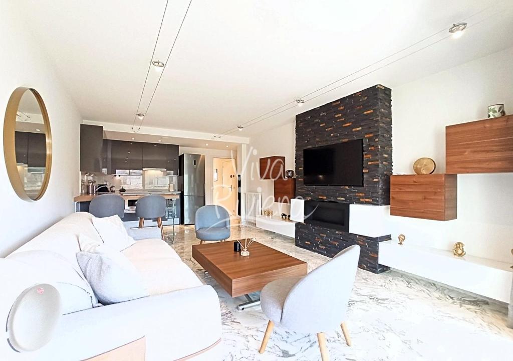 un salon avec un canapé blanc et une cheminée dans l'établissement Viva Riviera Luxury 2 Bedrooms Residence les Tuileries, à Cannes