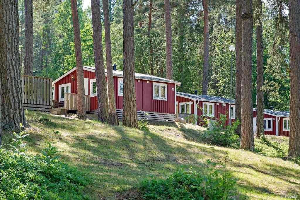 a row of red and white cabins in a forest at First Camp Kolmården-Norrköping in Kolmården