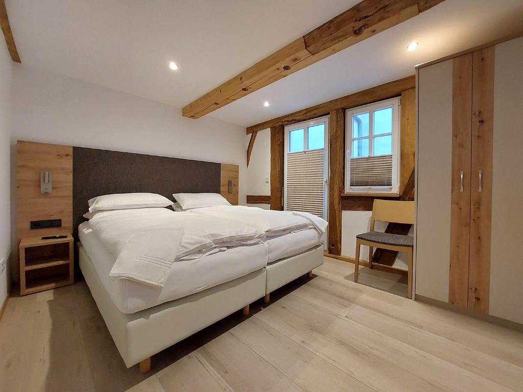 a bedroom with a large white bed and a desk at Gasthaus zum Ochsen in Mönchberg