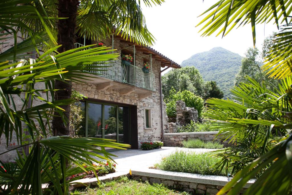 a stone house with a balcony and a garden at Home Cà D'la Butina in Mergozzo