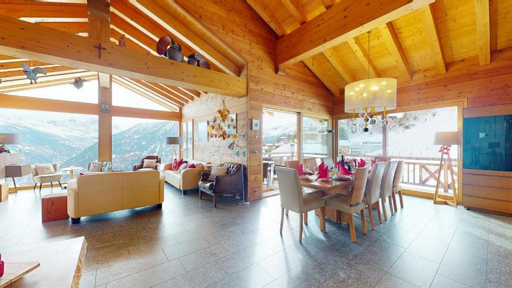 a dining room with a table and chairs and mountains at Etoiles des Neiges LUXE & JACUZZI chalet 12 pers by Alpvision Résidences in Hérémence