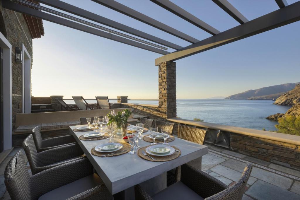 een tafel op een balkon met uitzicht op het water bij Seaview Beach House in Ándros