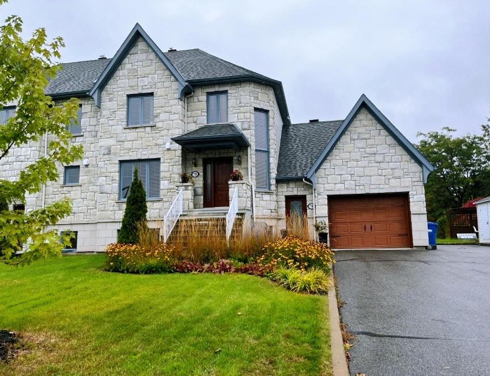 uma grande casa de pedra com garagem em Sweetwater House em Cidade de Quebec