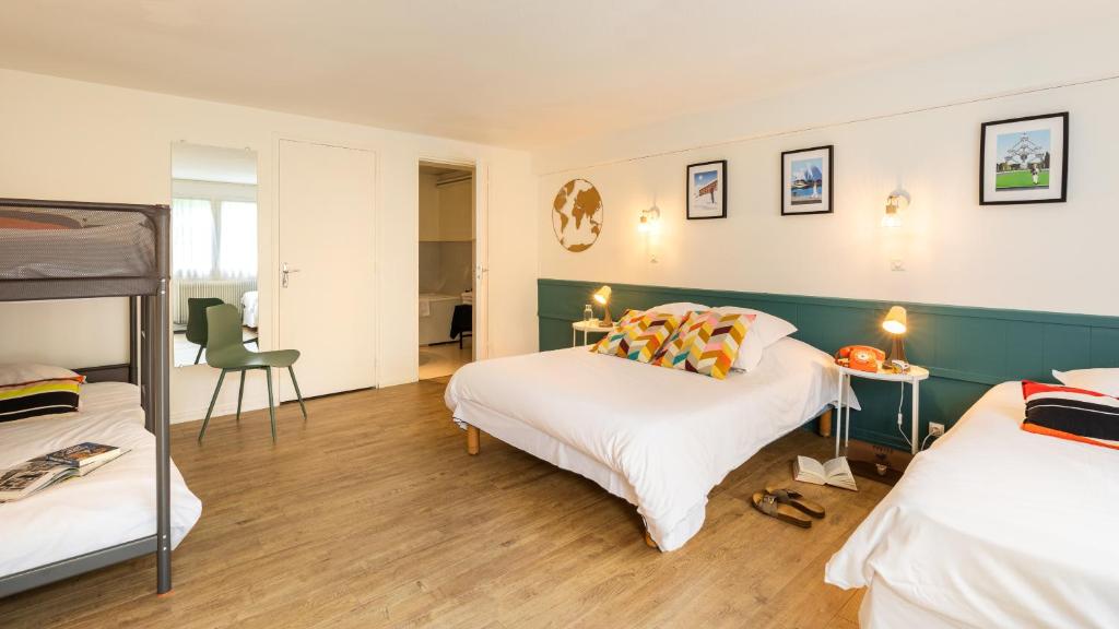 um quarto com 2 camas, uma mesa e cadeiras em Hôtel Les Hauts de Meursault em Meursault
