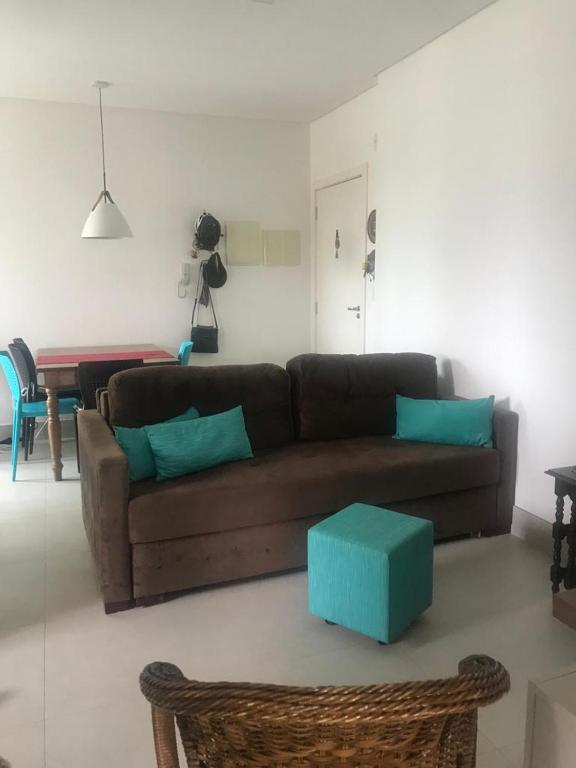 sala de estar con sofá marrón y mesa en Apartamento encantador, 100 m do mar, en Porto Belo