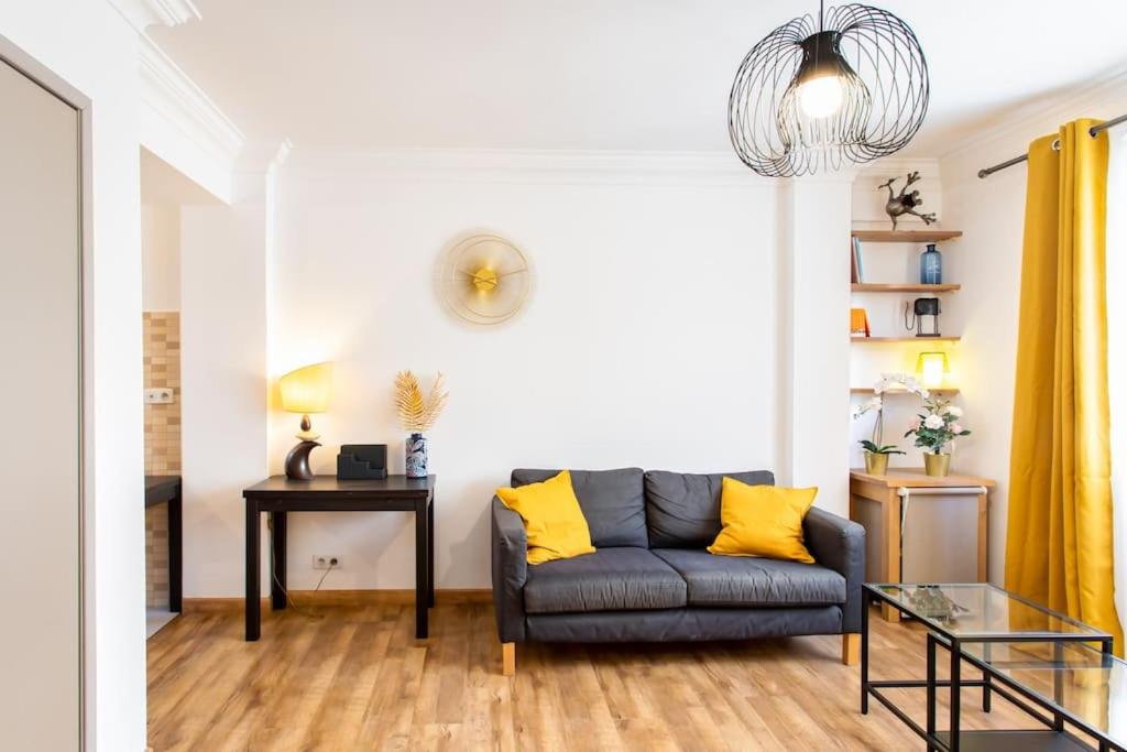 un salon avec un canapé et une table dans l'établissement #1 Studio Fontaine de la Ville-WIFI, à Nice