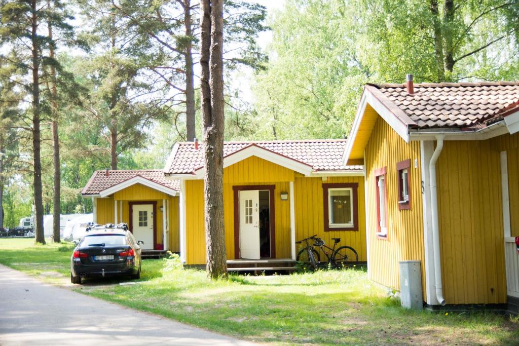 a row of small yellow houses with a car parked in front at First Camp Mellsta-Borlänge in Borlänge