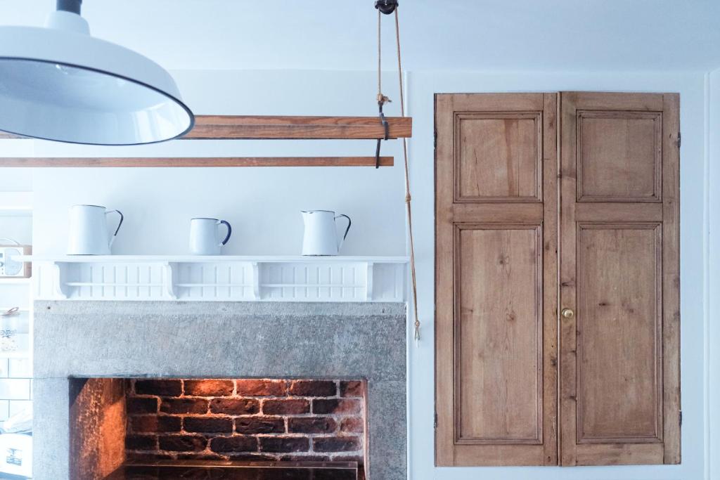 a kitchen with a fireplace and a wooden door at Gorgeous 3 bed house in Matlock + Garden ‘lookout’ in Matlock