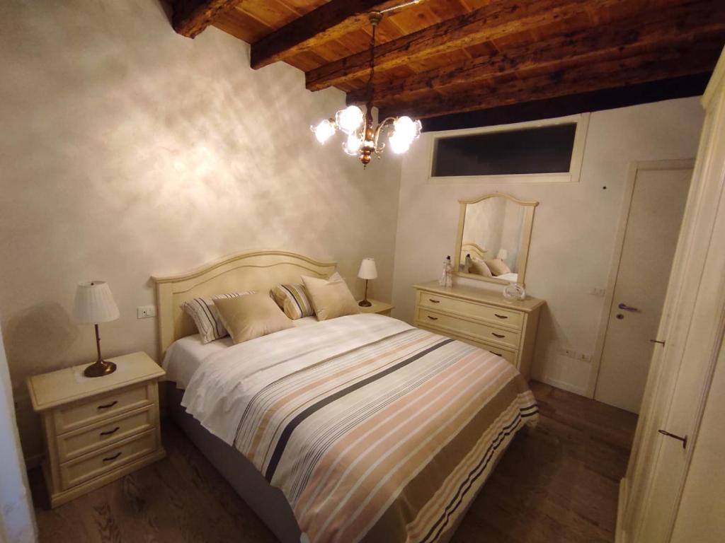 a bedroom with a large bed and two night stands at vivere al ponte vecchio in Bassano del Grappa